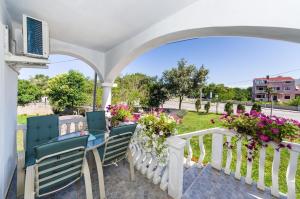 una veranda bianca con sedie e fiori di Apartments with parking space Zaton, Zadar - 15000 a Zaton
