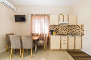 una cucina e una sala da pranzo con tavolo e sedie di Apartments with parking space Zaton, Zadar - 15000 a Zaton