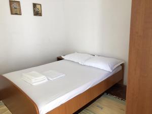 a small bed with white sheets and pillows on it at Secluded fisherman's cottage Cove Srhov Dolac, Hvar - 15087 in Gdinj +7 photos