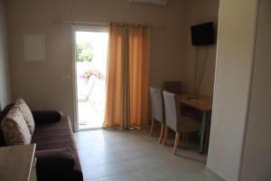 salon z kanapą, stołem i oknem w obiekcie Apartment Zaton 15000c w mieście Zaton