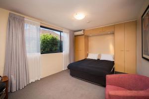 a bedroom with a bed and a chair and a window at Drummoyne Furnished Apartments in Sydney