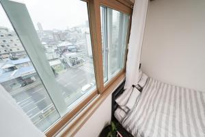 a bed in a room with a window at Sweet Stay in Seoul