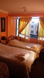 two beds in a hotel room with a window at Hostal "Oro Blanco" in Uyuni