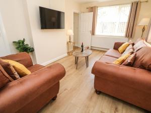 a living room with two brown couches and a table at Cedar Holme in Chesterfield