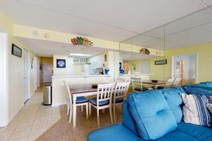 Sea Watch 1707 في آوشين سيتي: غرفة معيشة مع أريكة زرقاء وطاولة