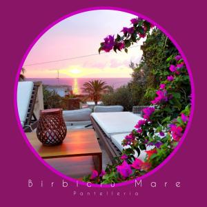 - une vue sur un patio fleuri et une table dans l'établissement Birbiciù mare, à Pantelleria