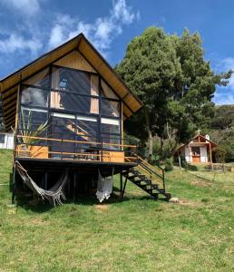 a house with a large window on top of a field at Mirador Valeisa in Guatavita