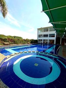 a large swimming pool with chairs and a building at Al Azhar Azhima Hotel Resort and Convention in Solo