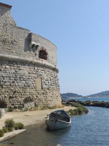 un barco sentado en el agua junto a un castillo en Le Côte d'Azur, en Toulon