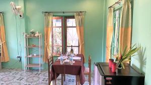 a dining room with a table and a window at Swiss Chalet Garden, Pool Resort in Krabi town