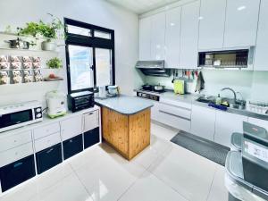 a kitchen with white cabinets and a wooden island at 迎迎民宿 in Toucheng