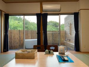 a room with a table and a large window at Alaise De Bale Shirahama in Shirahama