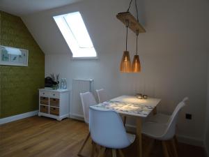 a dining room with a table and white chairs at Hygge Hus Langstedt in Langstedt