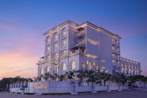 艾哈迈达巴德Hotel Hillock Ahmedabad的一座白色的大楼，前面有树