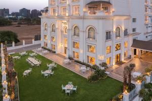 een luchtzicht op een groot wit gebouw met tafels en stoelen bij The Hillock Ahmedabad in Ahmedabad