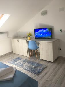 a living room with a tv and a blue chair at Vila Allure in Eforie Nord