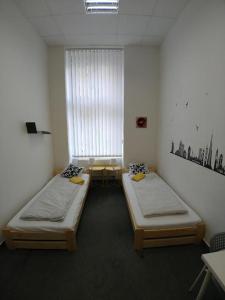 two beds sitting in a room with a window at ApartHostel Brno in Brno