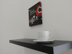 a book and a coffee cup on a black shelf at ApartHostel Brno in Brno