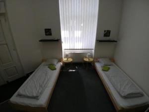2 camas en una habitación pequeña con ventana en ApartHostel Brno, en Brno