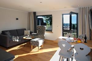 a living room with a couch and a table and chairs at Bergzauber Alpin Suites - Skipiste - Private Sauna in Bolsterlang