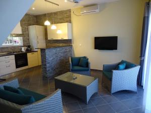 a living room with chairs and a table and a kitchen at Beach Villa in Nosy Be