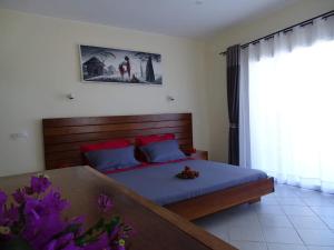 a bedroom with a bed and a table at Beach Villa in Nosy Be