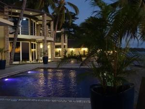 a villa with a swimming pool at night at Beach Villa in Nosy Be