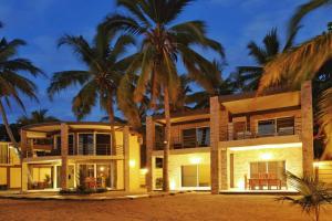 a house on the beach with palm trees at Beach Villa in Nosy Be