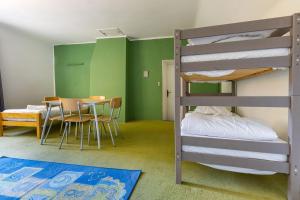 - une chambre avec des lits superposés, une table et une salle à manger dans l'établissement Le Gite du Chevreuil, 200 Mètres de BEAUVAL, à Saint-Aignan