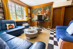 a living room with blue couches and a tv at Le Gite du Chevreuil, 200 Mètres de BEAUVAL in Saint-Aignan