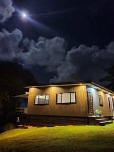 a house lit up at night with a moon at Tematas Mountain Villa in Avarua