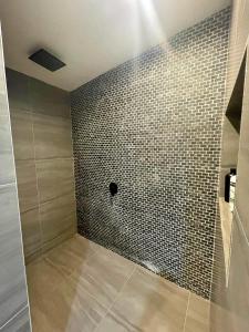 a bathroom with a shower with a tiled wall at Tematas Mountain Villa in Avarua