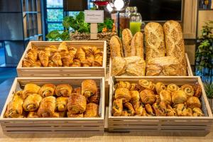 uma exibição de pão e pastelaria em bandejas numa padaria em ibis Orleans Centre Gare em Orléans