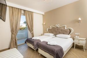 two beds in a hotel room with a window at Grand Hotel Park in Dubrovnik