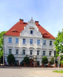 un gran edificio blanco con techo rojo en Hotel Krokus, en Kamienna Góra