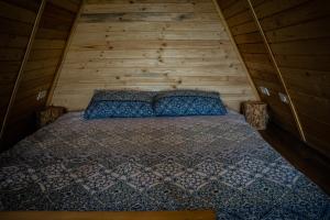 een slaapkamer met een bed in een houten hut bij Casuta Mea in Piatra Neamţ