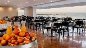 テルアビブにあるクラウンプラザホテル テルアビブビーチのテーブルと椅子、フルーツの盛り合わせが備わる客室です。