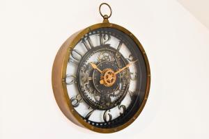 a black and gold clock hanging on a wall at T2 Confort et Tranquillité deuxième étage in Bergerac