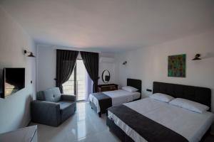 Pokój hotelowy z łóżkiem i krzesłem w obiekcie Imbrossa Hotel w mieście Gokceada