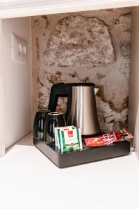 eine Kaffeemaschine auf einem Regal neben einer Wand in der Unterkunft Šibenik Palace in Šibenik