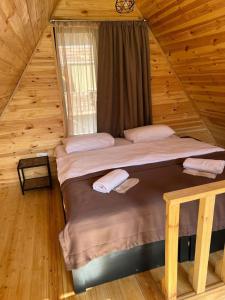 a bedroom with two beds in a log cabin at Kazbegi 4 side cottages in Stepantsminda