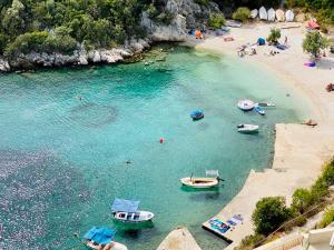 un groupe de bateaux dans l'eau sur une plage dans l'établissement Apartments Jasmina, à Vinišće