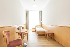 una camera ospedaliera con un letto e un tavolo con sedie di Pension Fünfhaus a Vienna