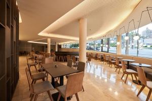a restaurant with tables and chairs and a large window at Hotel Bristol 4 Sup in Benidorm