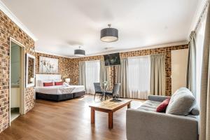 a living room with a couch and a bed at Richmond Motor Inn in Ballina