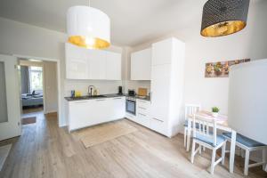 una cucina con armadi bianchi, un tavolo e una sala da pranzo di FULL HOUSE Studios - L96 2 Bedroom Apartment a Zwickau