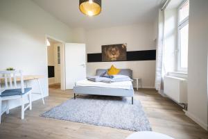 ein weißes Schlafzimmer mit einem Bett und einem Schreibtisch in der Unterkunft FULL HOUSE Studios - L96 2 Bedroom Apartment in Zwickau