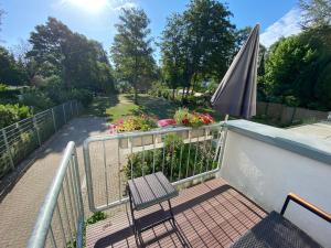 a balcony with a chair and an umbrella and flowers at Atelier-Ferienwohnung in Mülheim an der Ruhr