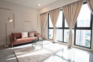 The Ooak Suites and Residence@ Kiara 163 في كوالالمبور: غرفة معيشة مع أريكة ونوافذ كبيرة