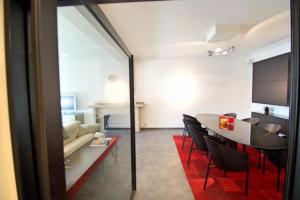 een eetkamer en een woonkamer met een tafel en stoelen bij Olympiade Bridge Penthouse 2 bedroom and outside of low emission zone in Antwerpen